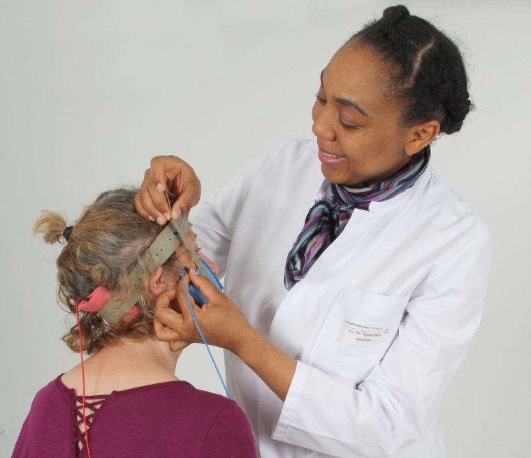 Dr. Carine Nguemeni beim Anlegen der Vorrichtung zur transkraniellen...