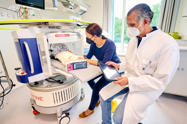 Priv.-Doz. Dr. Hemmen Sabir untersucht ein Neugeborenes mit dem mobilen MRT und...