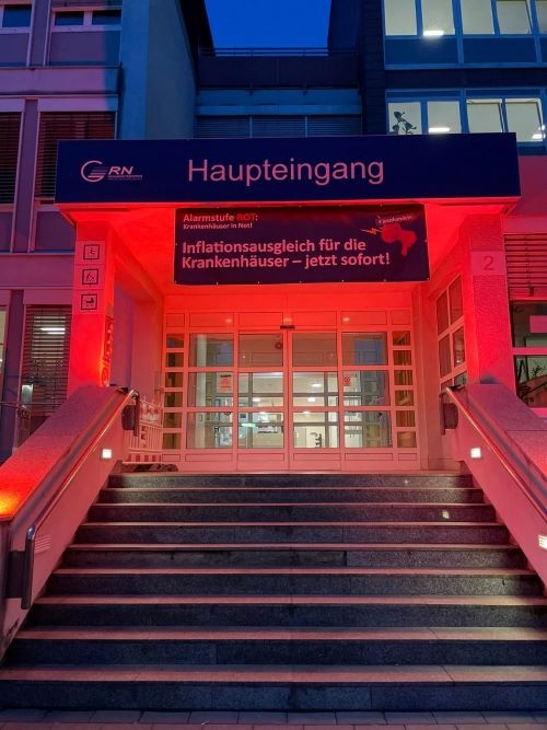 Der Eingang zum Krankenhaus ist rot erleuchtet am Aktionstag Alarmstufe rot -...