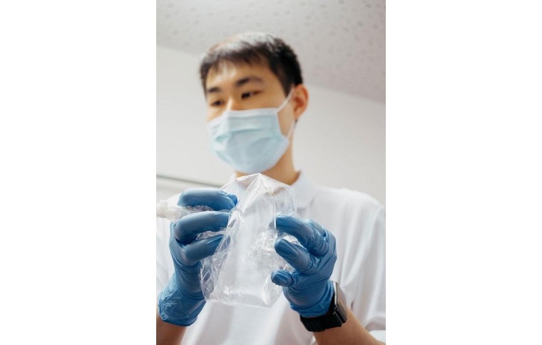Erstautor Jiafa Zeng drückt die Atemluft aus dem Probenbeutel in ein...